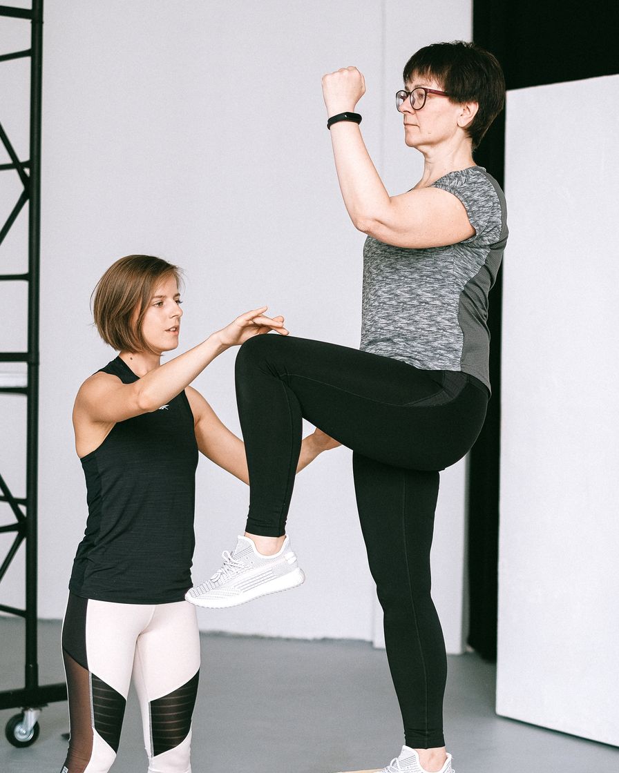 A physiotherapist guiding a client through a balance exercise